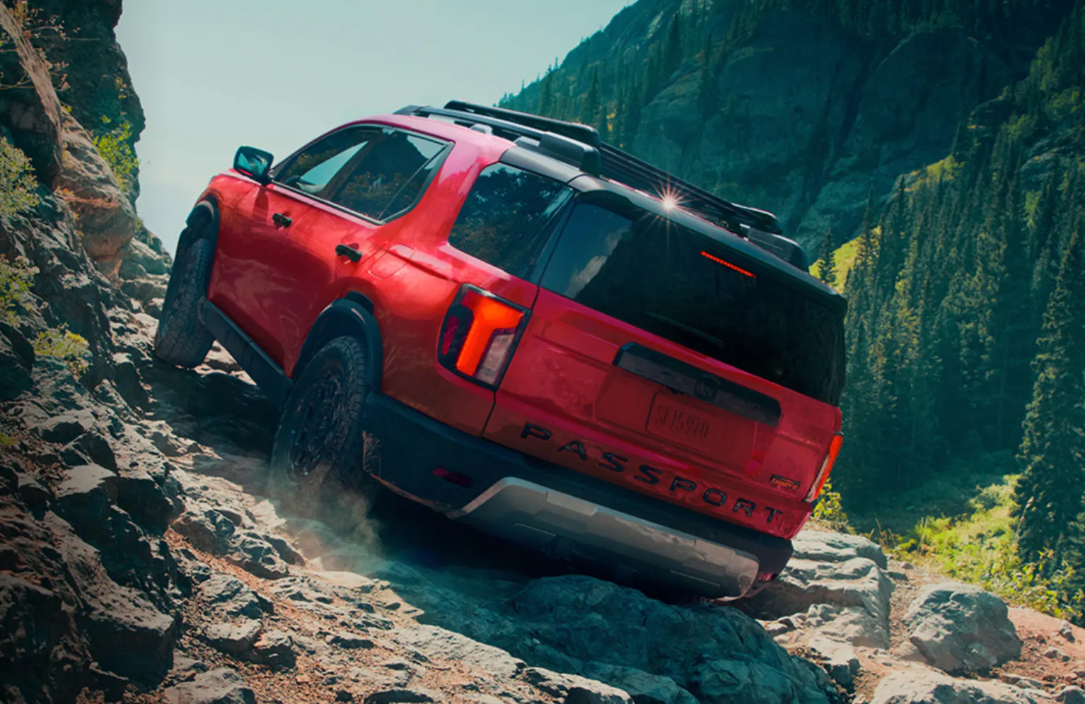 A red Honda Passport climbs rocky terrain
