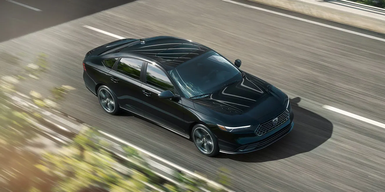 Black Honda sedan driving on a multi-lane highway, viewed from above with motion blur emphasizing speed.