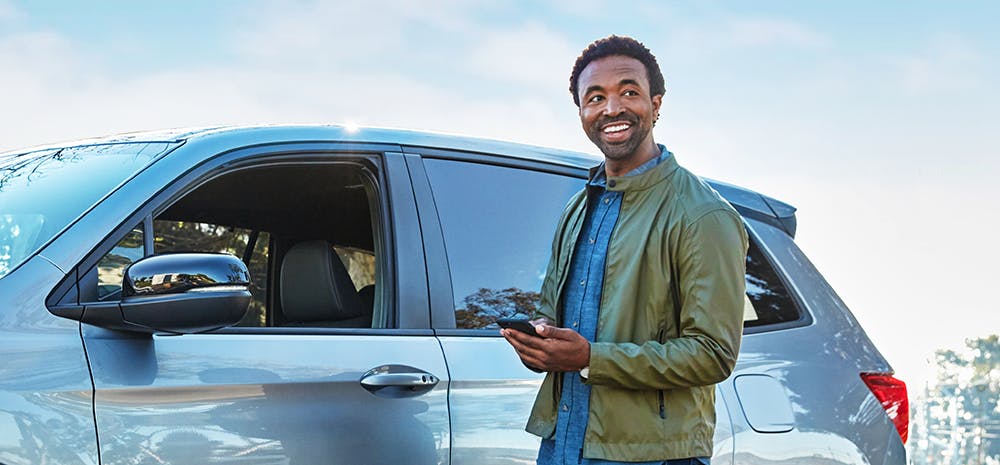 customer-smiling-at-car Man smiling next to car