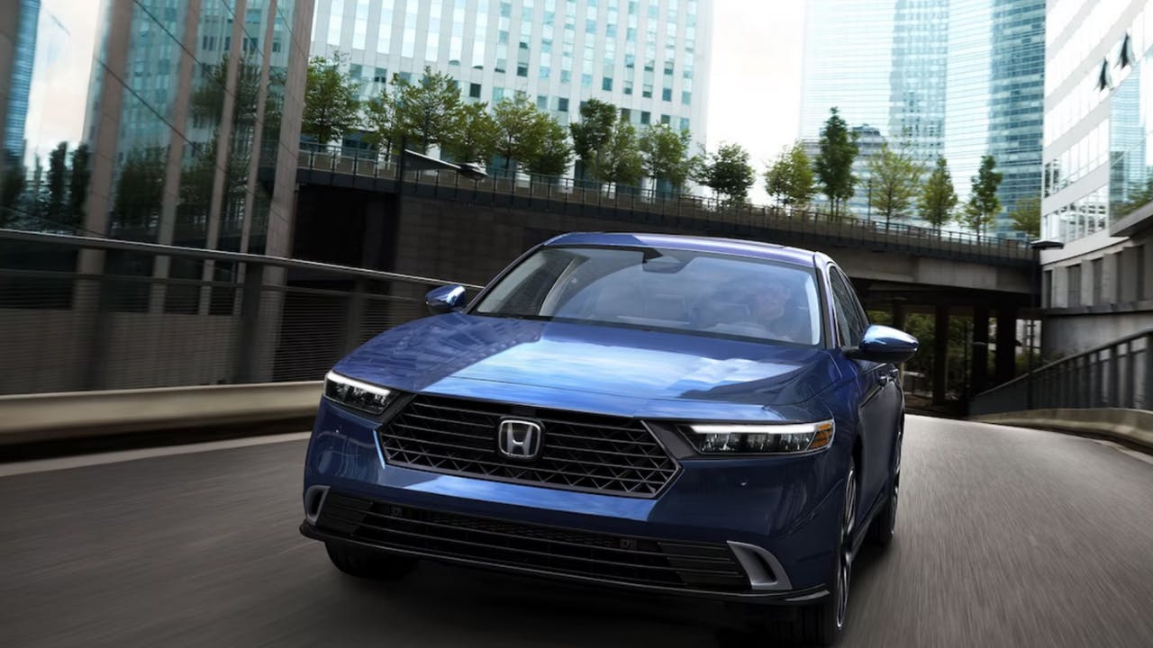 Touring Hybrid shown in Canyon River Blue Metallic driving through cityscape