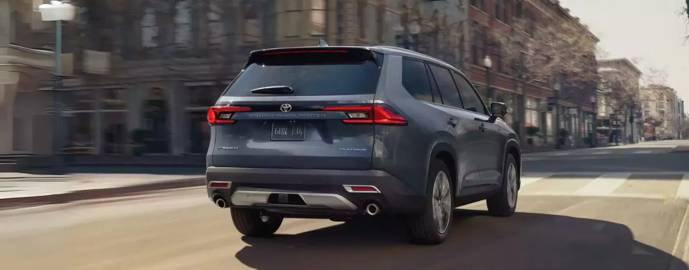 Grey 2025 Toyota Grand Highlander driving through a city