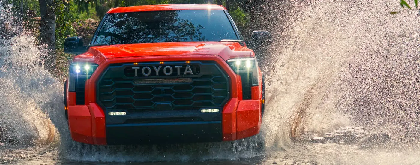 Orange 2022 Toyota Tundra TRD Pro crossing a stream