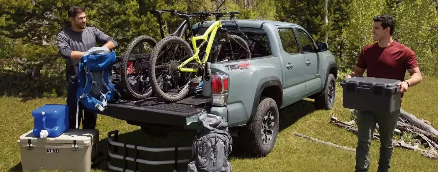 People unloading gear from a grey 2023 Toyota Tacoma TRD