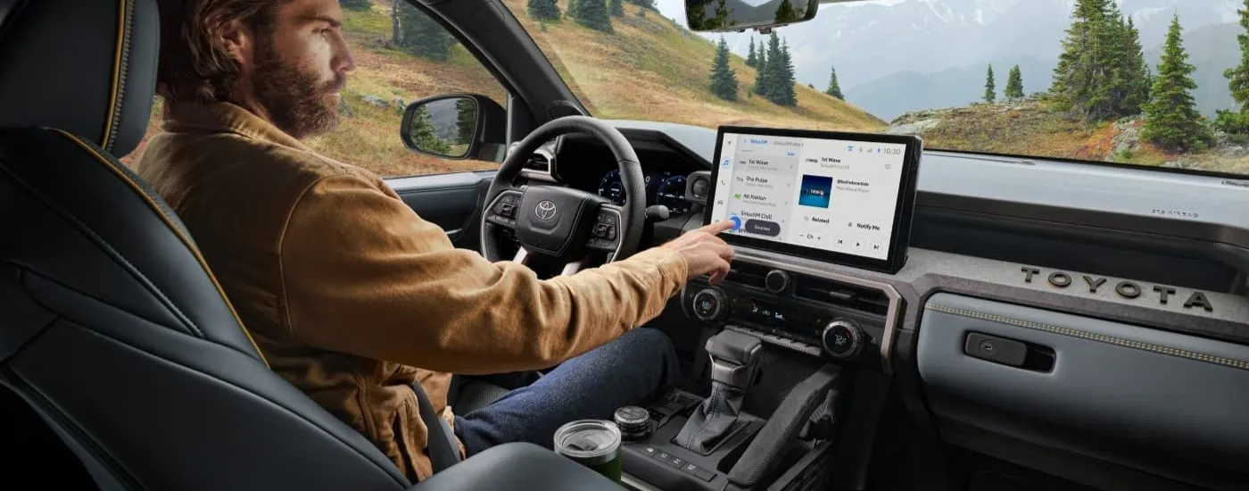 Person using the infotainment screen in a 2024 Toyota Tacoma