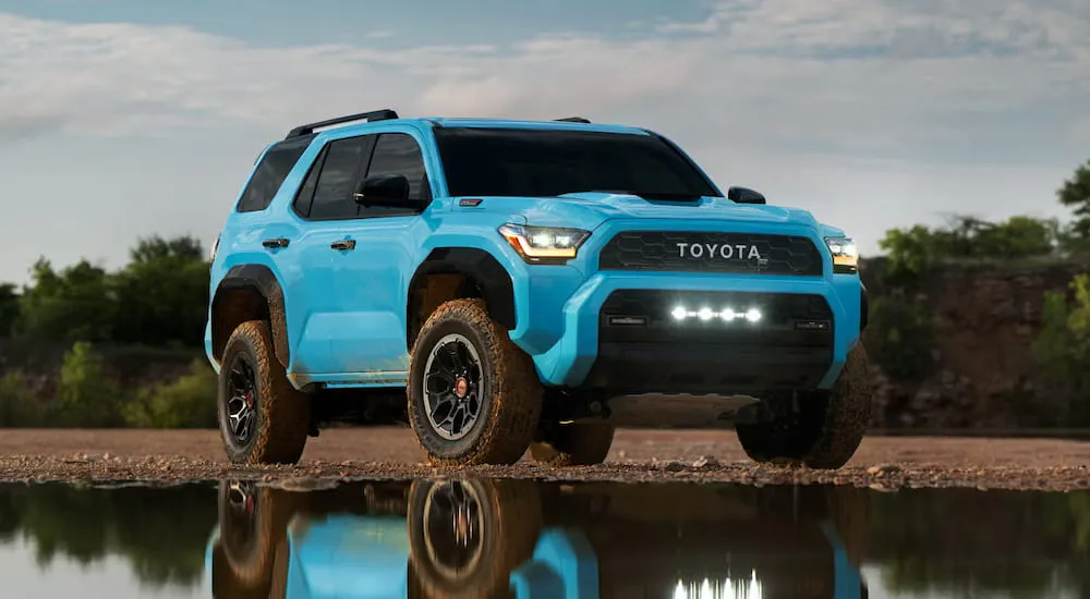 Blue 2026 Toyota 4Runner parked off-road near a lake.