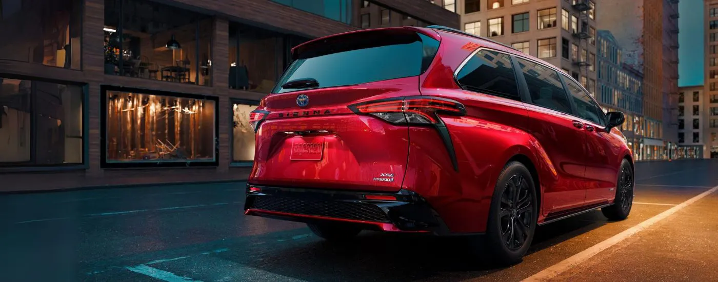 Rear of a red 2025 Toyota Sienna in a city.
