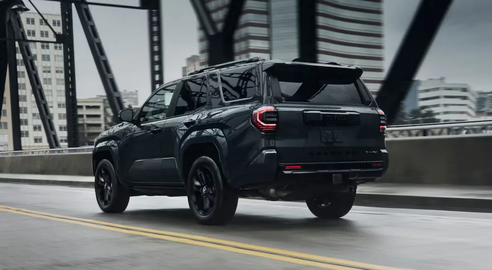 Rear of a black 2026 Toyota 4Runner driving on a bridge.