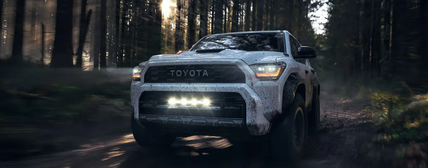 Silver 2026 Toyota 4Runner driving off-road through a forest.