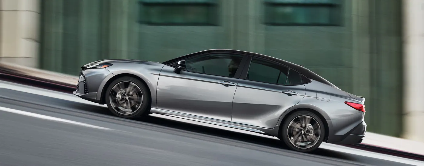 Silver 2026 Toyota Camry driving up a hill