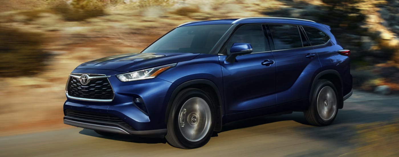 Blue 2026 Toyota Highlander from driving down the road