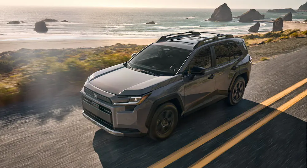 High view of a brown 2026 Toyota RAV4 driving down a road.