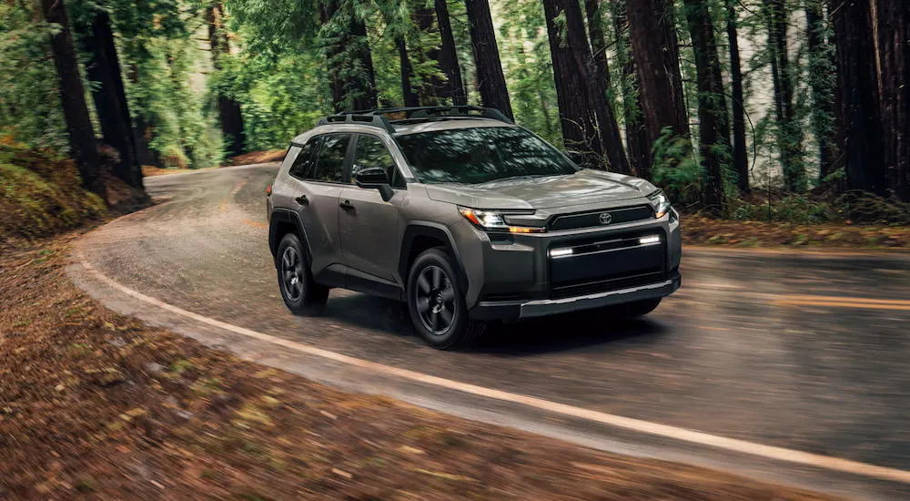 Grey 2026 Toyota RAV4 driving around a bend.