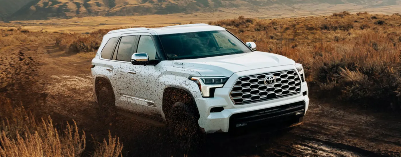 White 2026 Toyota Sequoia driving through mud