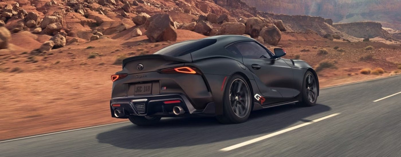 A black 2026 Toyota Supra from the rear at an angle after leaving a Toyota dealer.