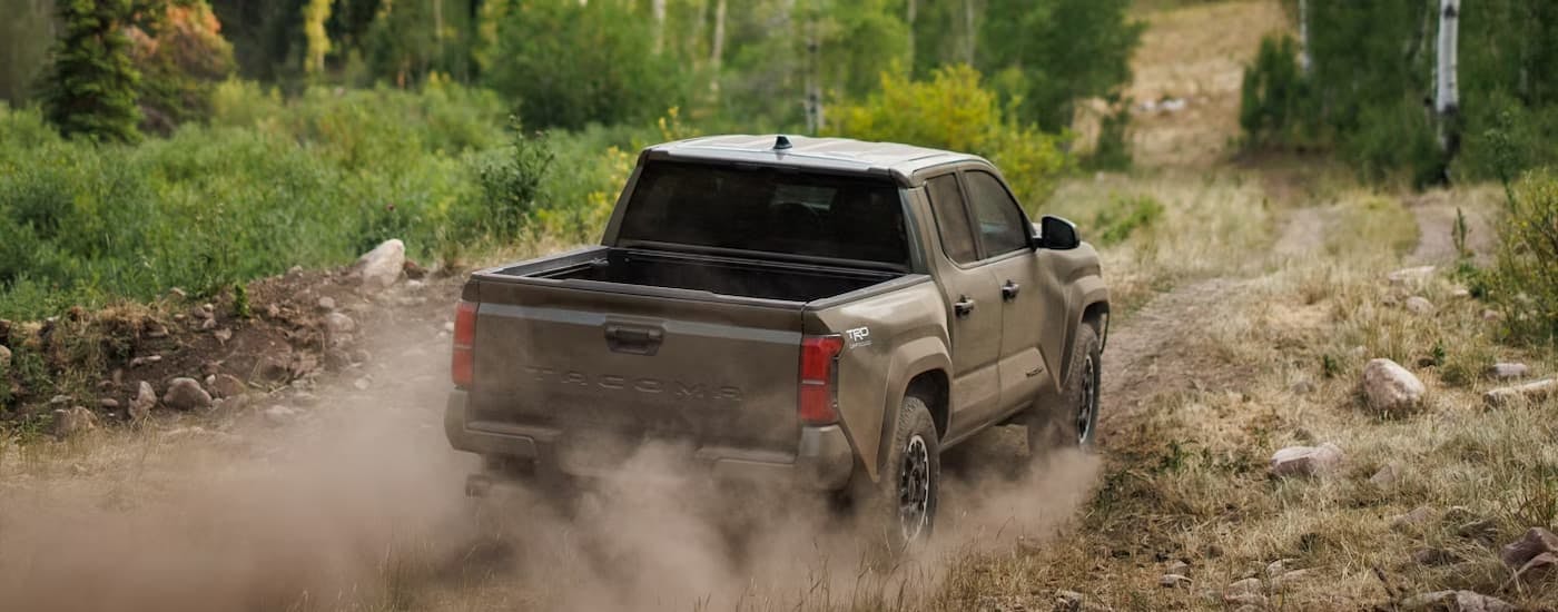 Brown 2026 Toyota Tacoma off-roading on a dirt path