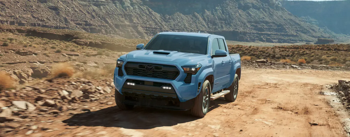 Blue 2026 Toyota Tacoma driving through a canyon