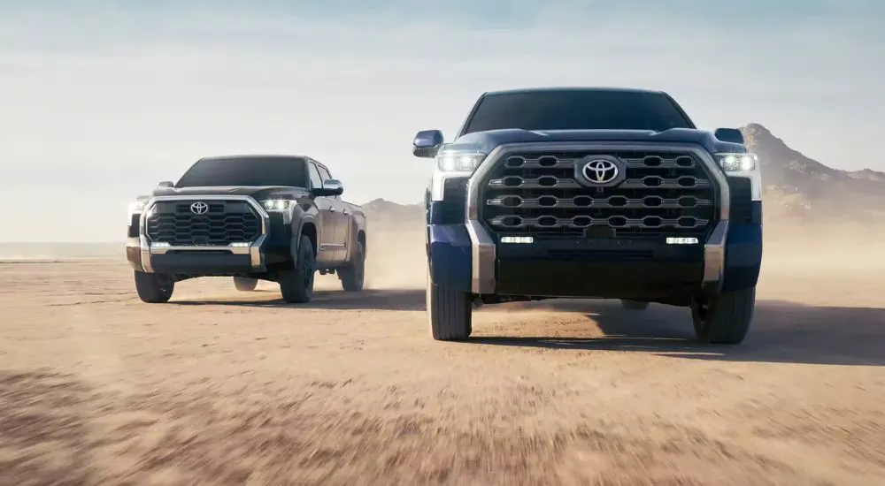 Blue 2026 Toyota Tundra 1794 driving next to a black 2026 Toyota Tundra Platinum