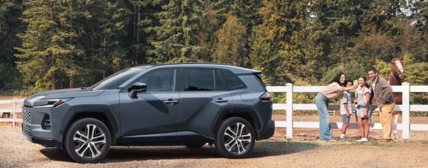 A family standing next to their grey 2026 Toyota RAV4