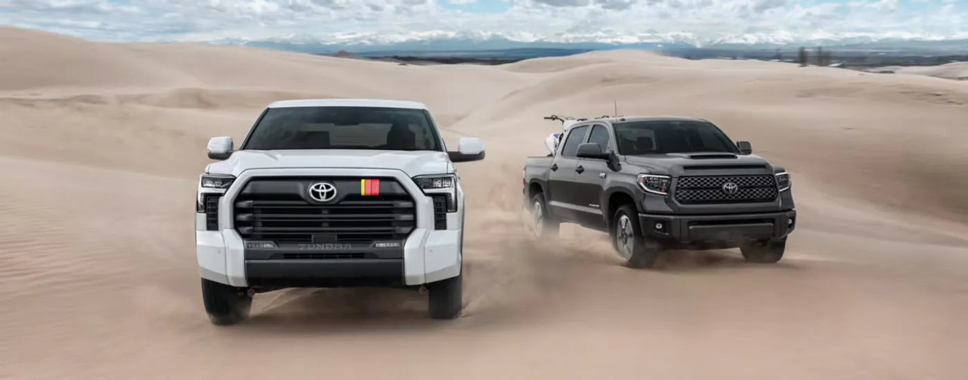 White 2026 Toyota Tundra Rally Edition driving next to a black 2026 Toyota Tundra