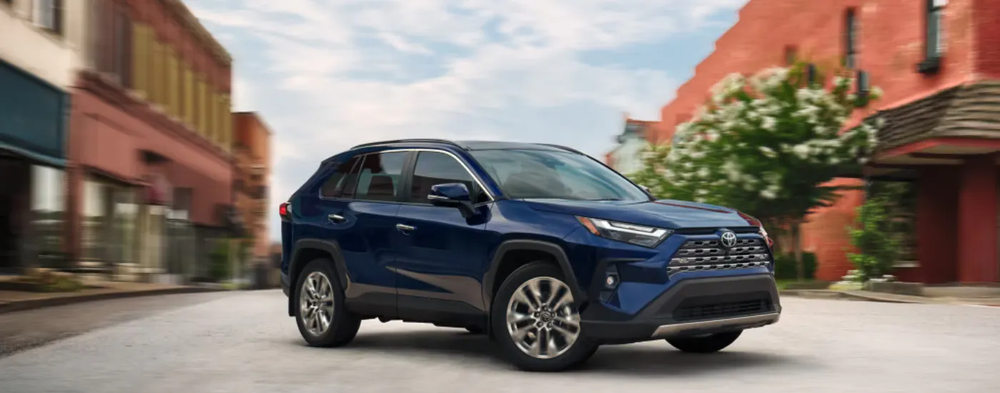 Blue 2025 Toyota RAV4 parked at an angle in a town
