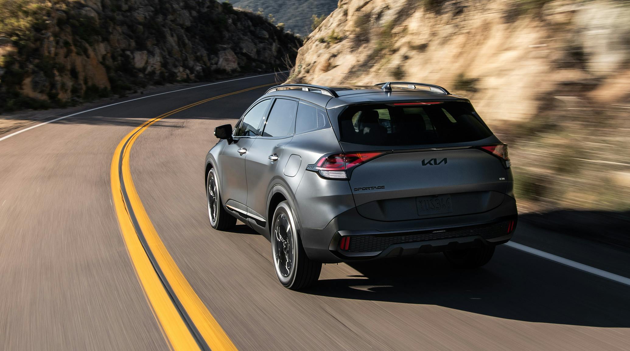 kia sportage grey driving down a road