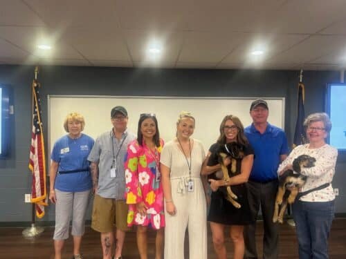 group of people holding puppies