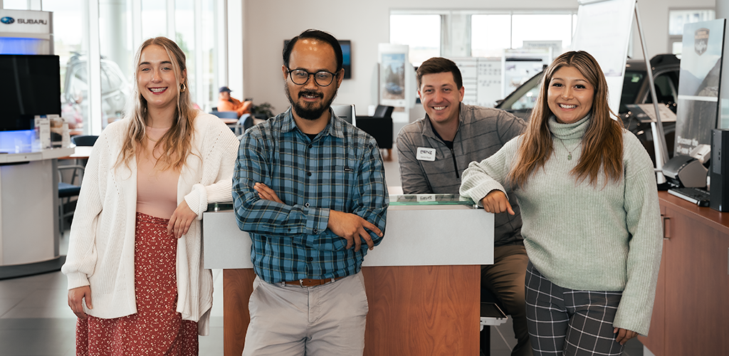 Four office staff smiling