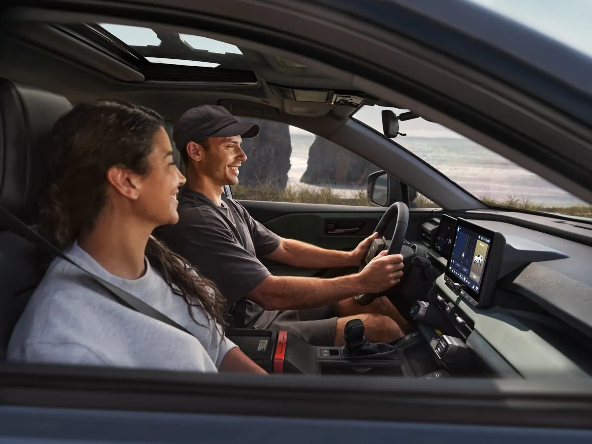 Owners driving happily in a 2026 Toyota RAV4