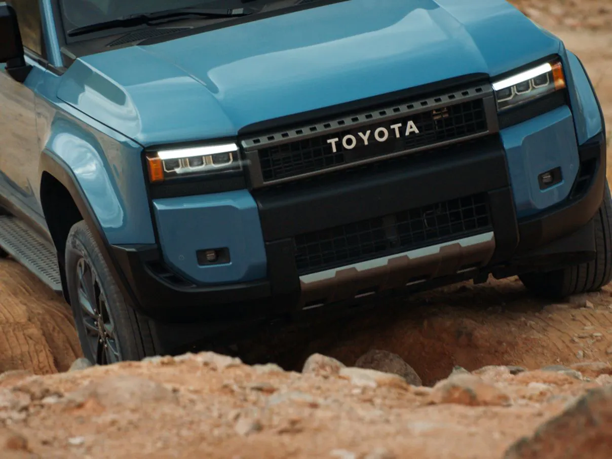 The 2027 Toyota Land Cruiser crawling over rocky terrain