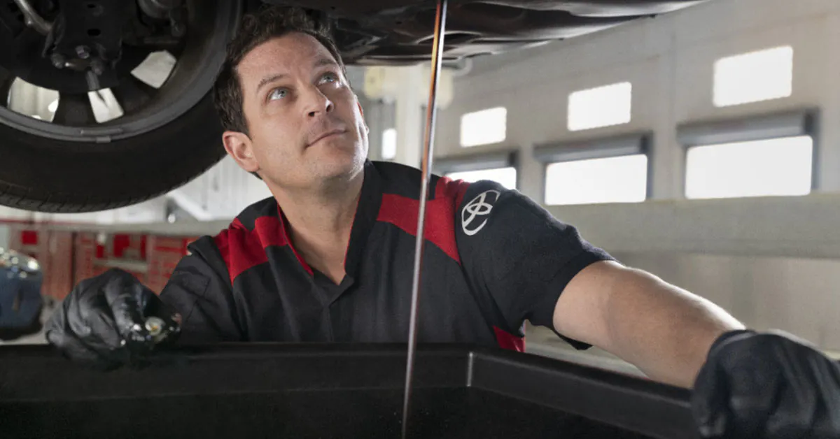 Toyota service technician working on an oil change