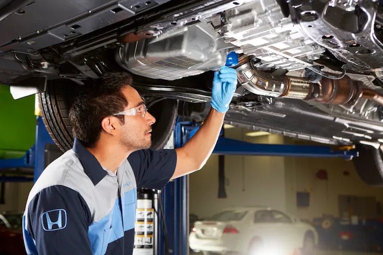 technican-working-under-lefted-vehicle