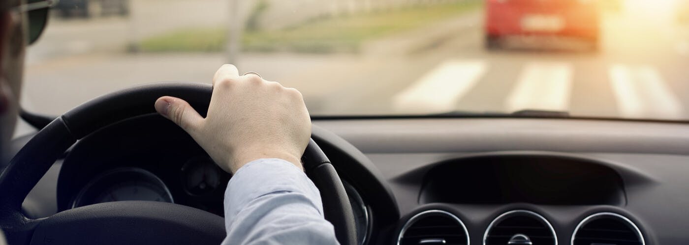 Man driving with one hand