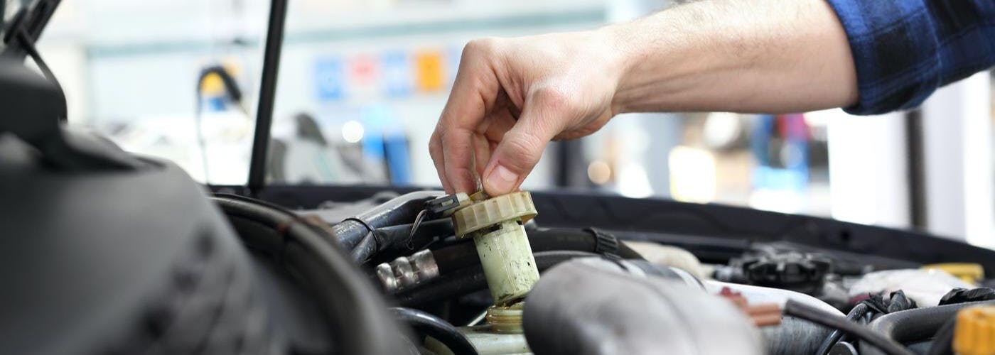 service technician checking brake fluid