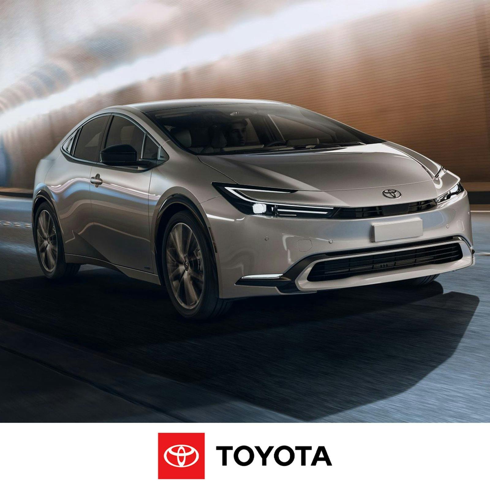 A white Toyota Prius in motion inside a tunnel with lighting and blurred brick wall