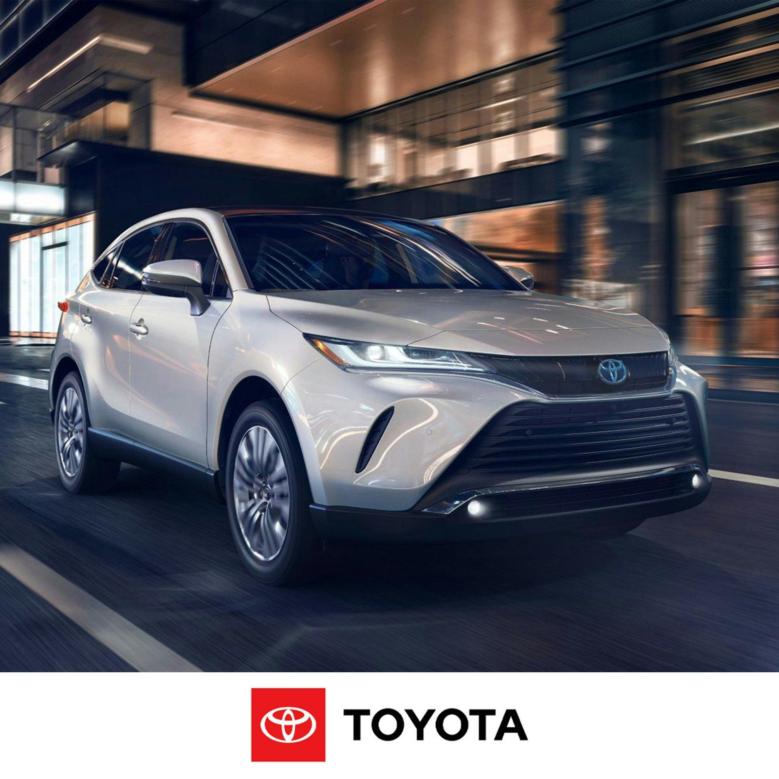 A Toyota Venza in motion on a city street with a blurred background of buildings