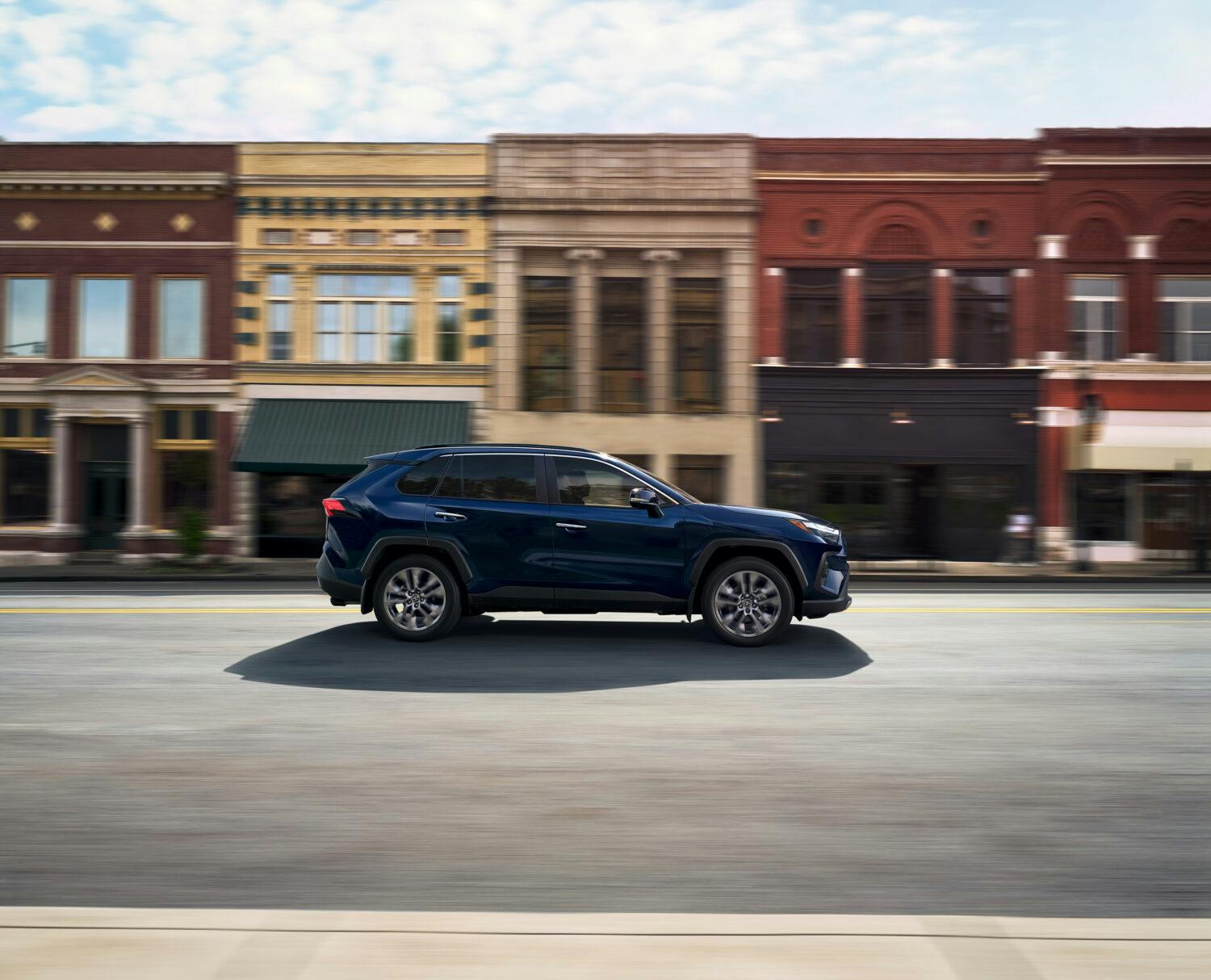 2025 Toyota RAV4 Blueprint driving through a quaint Main Street