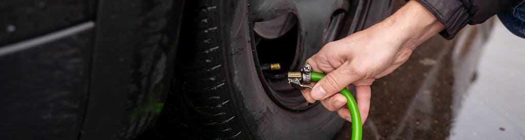 Tire Pressure Information at Team Toyota of Glen Mills in Glen Mills, PA | close up of person about to connect tire pressure hose to tire