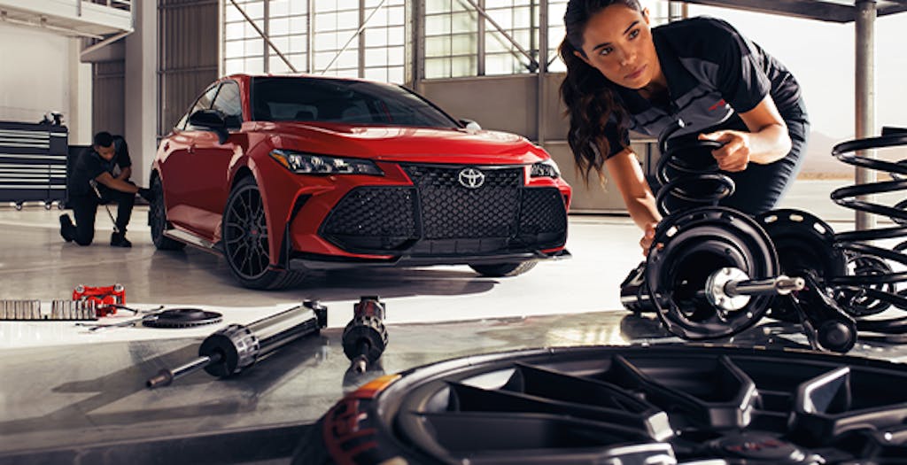 3 Main Benefits of Using OEM parts for your vehicle at Team Toyota of Glen Mills in Glen Mills, PA | Female mechanic grabbing some Toyota OEM parts for the red Camry right behind her