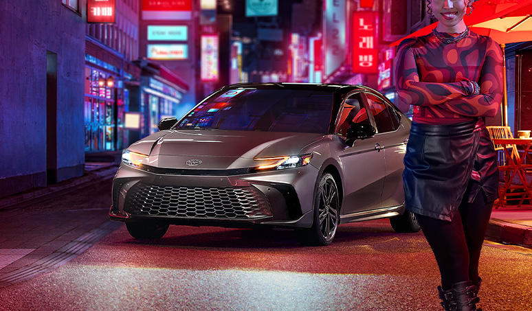 Most Fuel Efficient Toyota Models at Team Toyota of Glen Mills | Person standing in front of a new 2024 Toyota Camry in the color silver