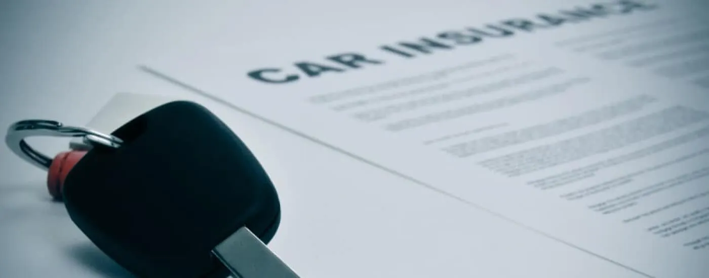 An automobile key laying on a piece of paper.