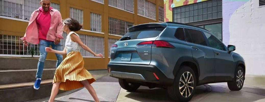 ppl-Toyota-Corolla-Cross-Featur man and woman dancing by a blue SUV