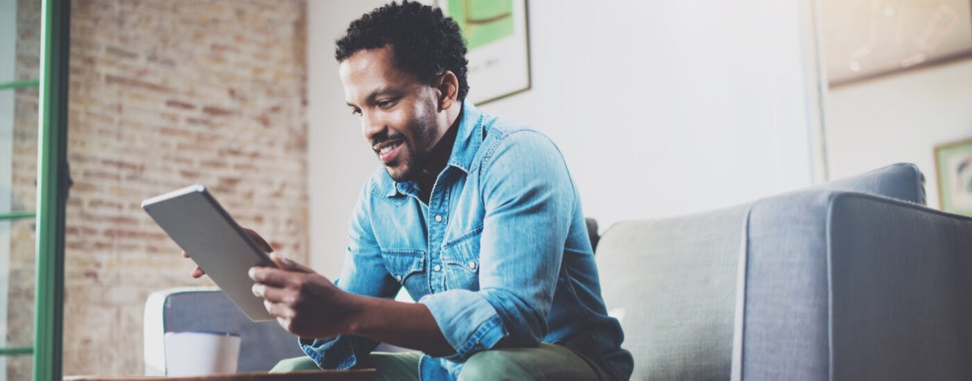 man on couch with tablet